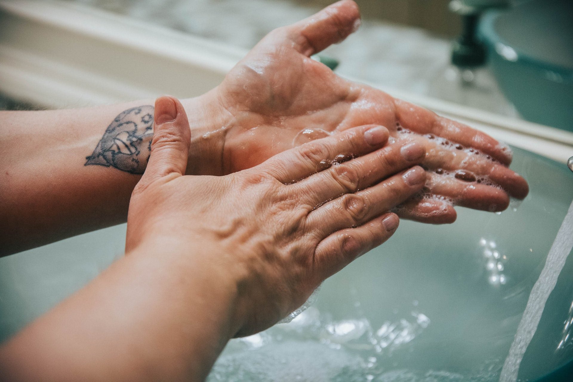 Person washing their hands over basin
