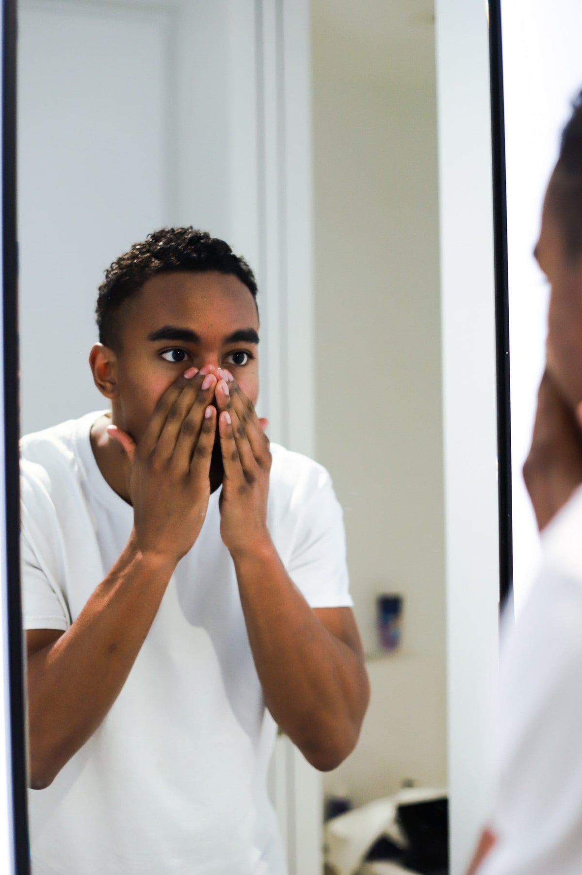man applying goats milk lotion and goats milk cream to face