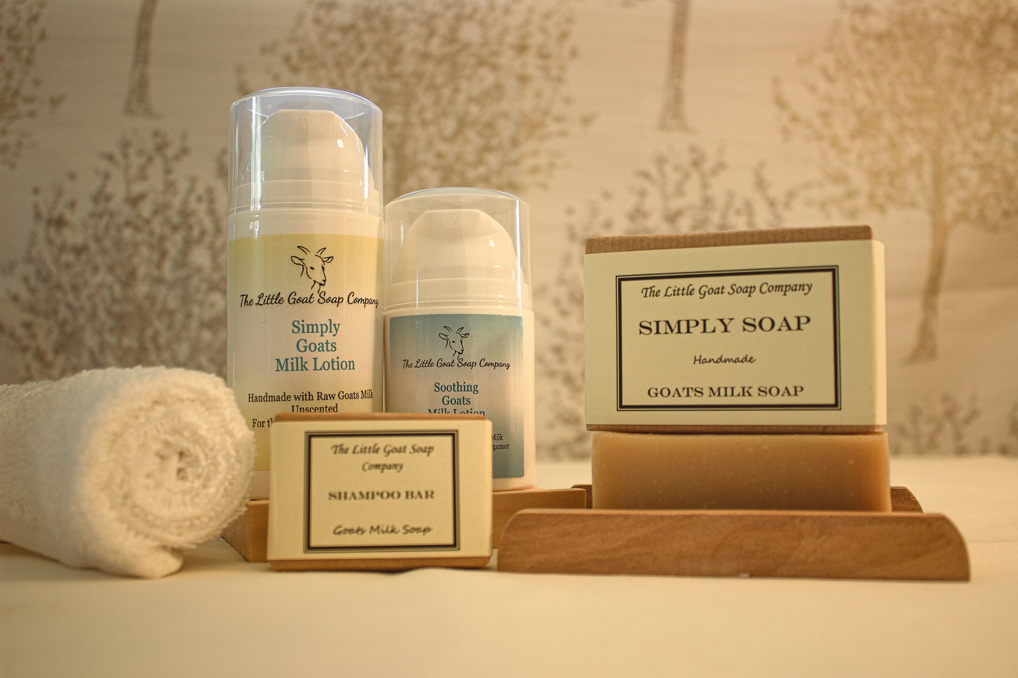 Image of both large and small Simply Soap Goats Milk Soap, in the background there is also 2 cans of goat milk lotion.