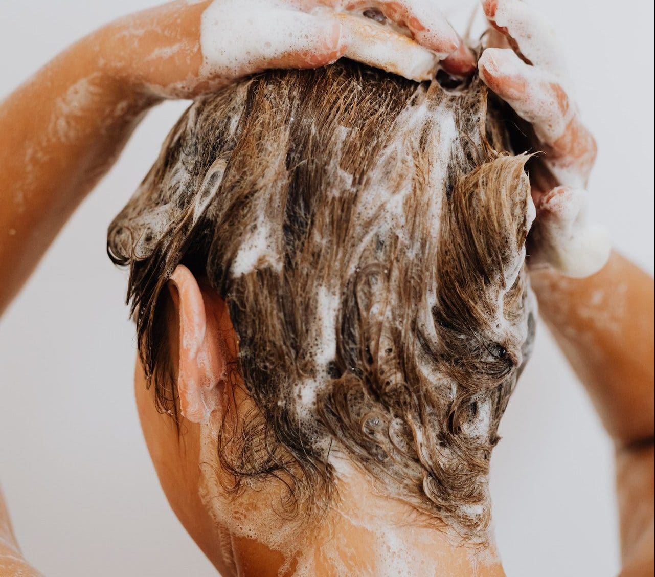 woman washing hair with goats milk shampoo bar